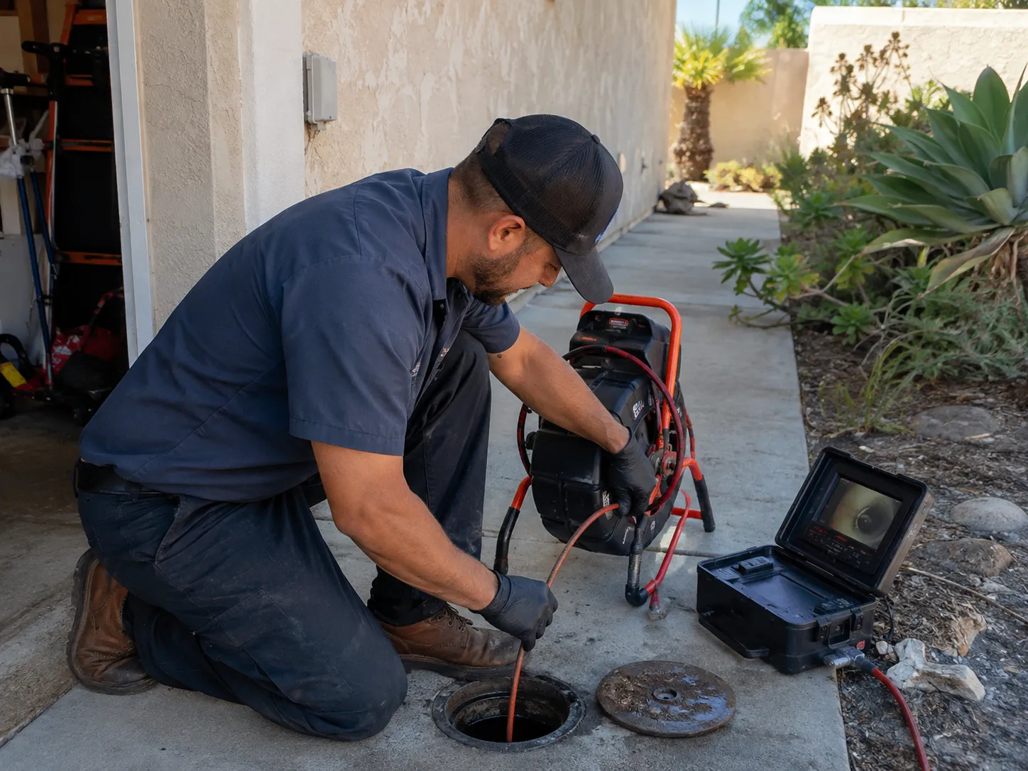 San Diego County plumber inspecting and cleaning a residential main sewer line through an exterior cleanout